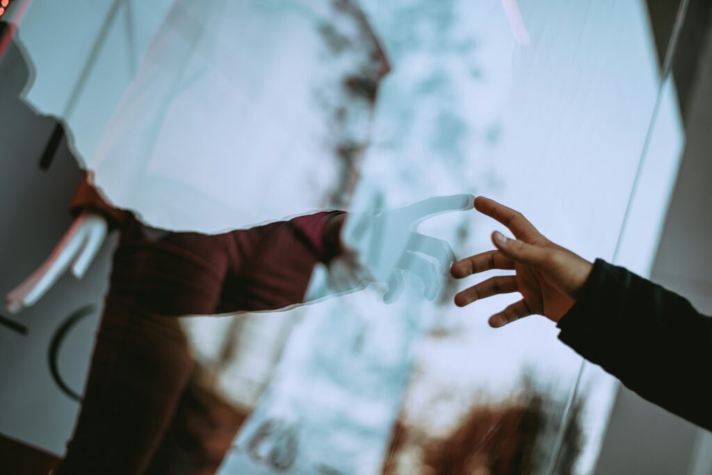 Image of a person touching a mirror, symbolizing perceiving ourself and our own experience.